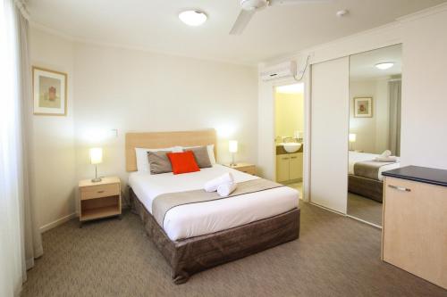 カラウンドラにあるCaloundra Central Apartment Hotel Officialのベッドルーム(大型ベッド1台、鏡付)