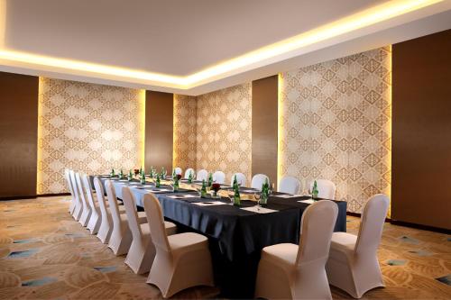 a long table in a room with white chairs at Resinda Hotel Karawang in Karawang