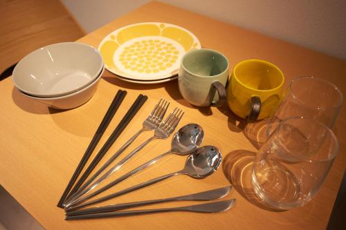a table with plates and utensils on it at Bellie Sangenjaya by Tranova in Tokyo