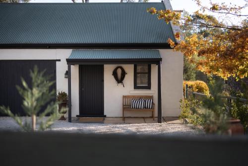 a house with a bench in front of a door at St Helen's Cottages in Clare