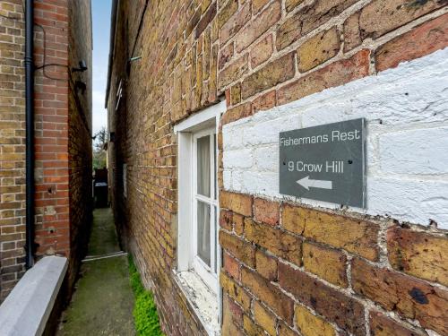 a brick wall with a sign on the side of a building at Fisherman's Rest in Broadstairs