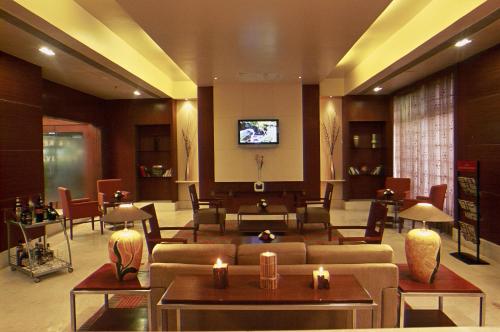 a lobby with couches and tables and a tv at Katriya Hotel and Tower in Hyderabad