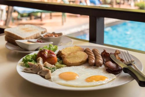 een bord ontbijtproducten met eieren, worst en brood bij Opey De Place in Pattaya