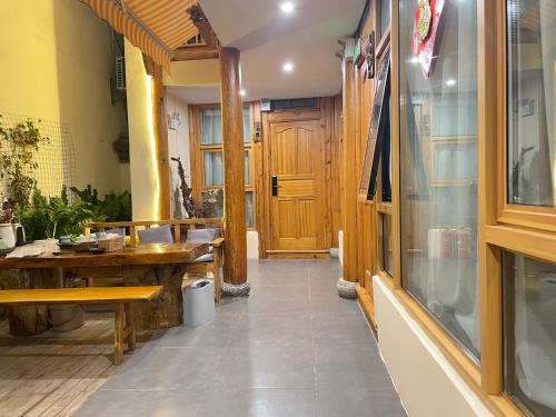 a restaurant with a table and a wooden door at Leisure Inn in Lijiang