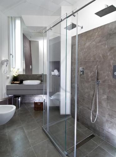 a bathroom with a glass shower and a sink at Acapulco Hotel in Cattolica