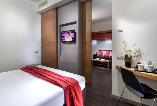 a bedroom with a bed with a red blanket on it at Acapulco Hotel in Cattolica