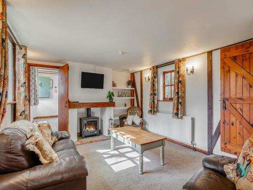 Rookery Cottage في Little Staughton: غرفة معيشة مع أريكة وطاولة