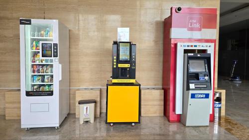 two atm machines sitting next to a refrigerator at Studio Apartment JiExpo Kemayoran View -Min Stay 3 nights- in Jakarta