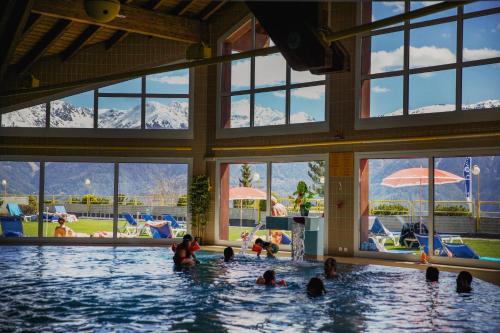 a group of people in the water in a swimming pool at Hôtel Les Bains d'Ovronnaz in Ovronnaz