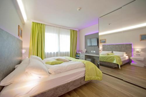 a bedroom with two beds and a large mirror at Aktivhotel Santalucia in Nago-Torbole