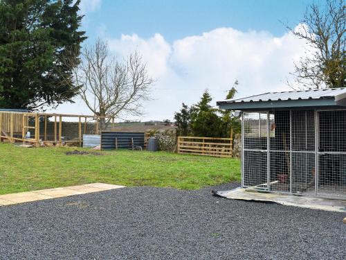 a bird cage sitting on the side of a yard at The Annex At Fernyrig in Birgham