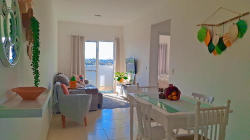 Una cocina y una sala de estar con mesa y sillas. en Apartamento para locação em Itajai SC, en Itajaí