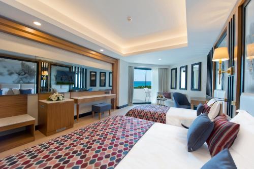 a hotel room with two beds and a desk at Adalya Elite Lara Hotel - Ultra All Inclusive in Lara
