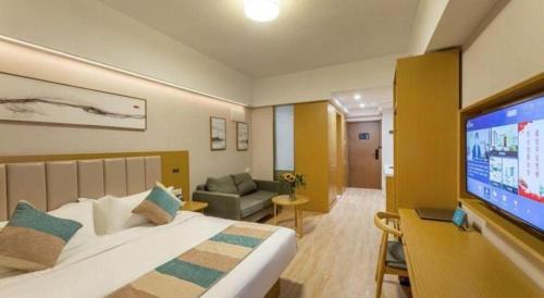 a hotel room with a bed and a flat screen tv at VX Hotel Wuxi Xinwu District Executive Center Wanda Plaza in Wuxi