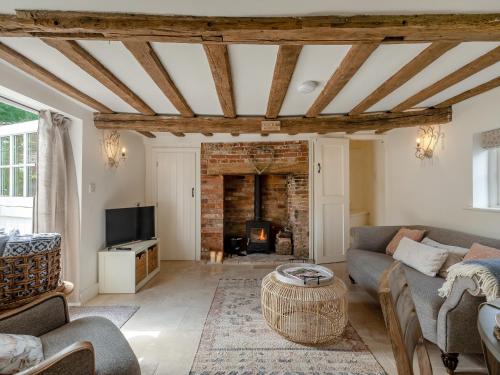 un soggiorno con divano e camino di Hope Cottage a Ilketshall Saint Andrew