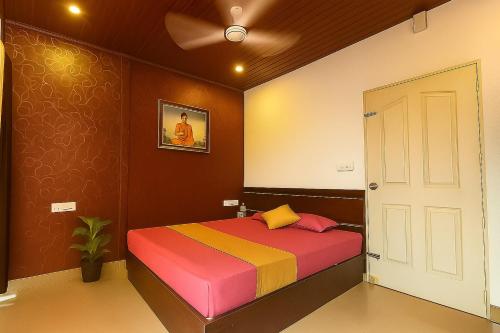a bedroom with a colorful bed and a ceiling fan at Hill side Home in Anachal