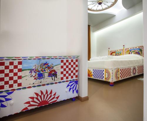 a room with two beds and a painting on the wall at Tra Le Braccia di Morfeo in Terrasini
