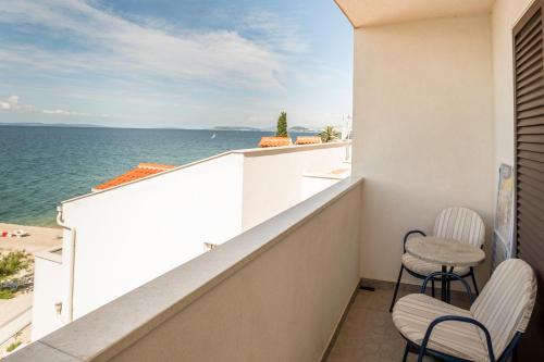 a balcony with two chairs and a view of the ocean at Villa Amigo in Podstrana