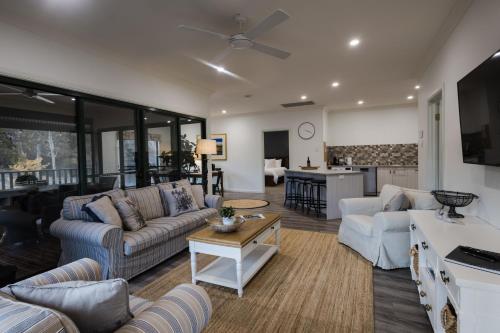 a living room with two couches and a kitchen at St Helen's Cottages in Clare