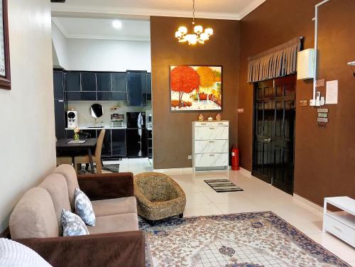 a living room with a couch and a kitchen at Sarrah Homestay At Kasa Height Residence in Kampong Alor Gajah