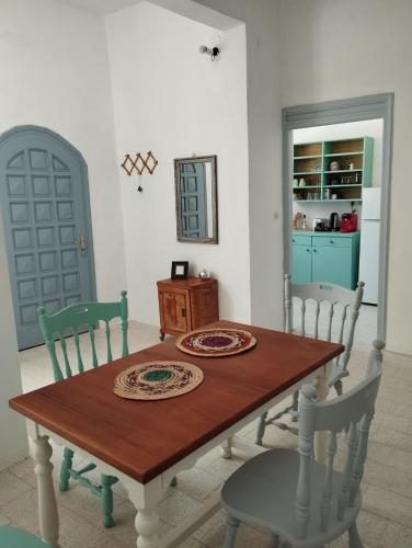 a dining room with a table and chairs and a kitchen at White Cat in Vromolithos