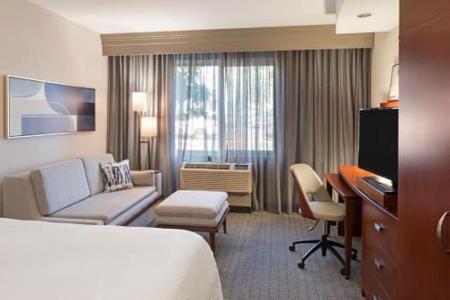 a hotel room with a bed and a desk at Courtyard Long Beach Airport in Long Beach