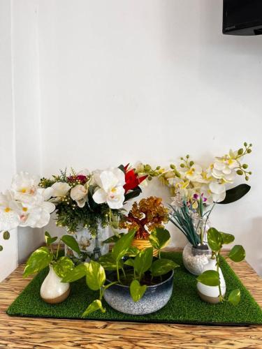 a group of vases with flowers and plants on a table at S8 Boutique Hotel near KLIA 1 & KLIA 2 in Sepang
