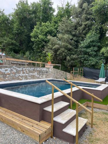 a swimming pool with a wooden deck and stairs around it at Villa Lilia by Let in Siena