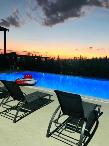 a swimming pool with two chairs and a table at DREAM VIEW Saguramo in Saguramo
