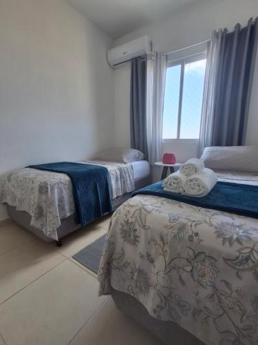 Un dormitorio con dos camas y una ventana en Apartamento para locação em Itajai SC, en Itajaí