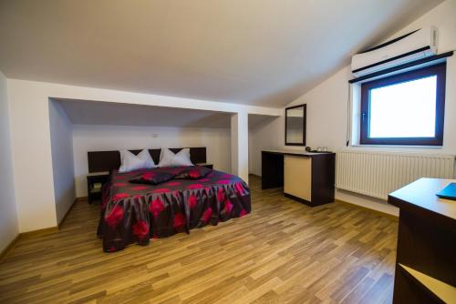 a bedroom with a bed and a desk and a window at Elina in Techirghiol