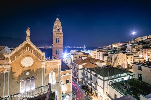 a building with a clock tower in a city at night at La Gaetana in Gaeta