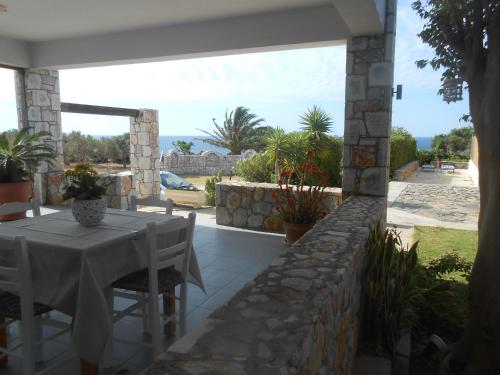 a patio with a table and chairs on a stone wall at Serenity Hideaway in Palaiochóra