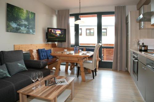 a living room with a couch and a dining room table at der Wildbachhof - Contactless check in in Zell am See