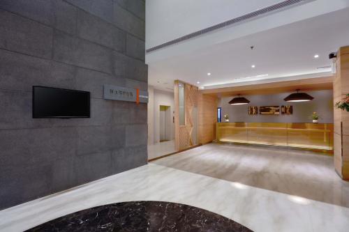 a large lobby with a flat screen tv on a wall at Harper MT Haryono by ASTON in Jakarta
