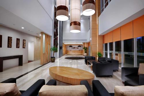 a lobby with a table and chairs and a fireplace at Harper MT Haryono by ASTON in Jakarta