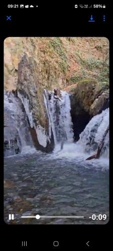 a tv screen with a picture of a waterfall at Nona Guest House in Shilda