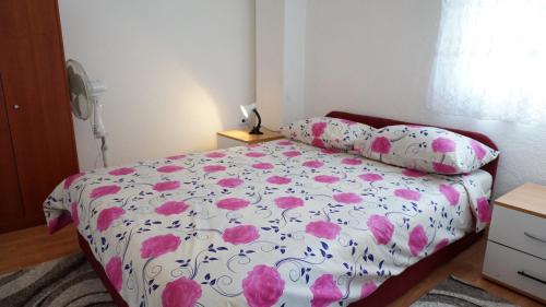 Un dormitorio con una cama con flores rosas. en Apartments Red Rose, en Nin