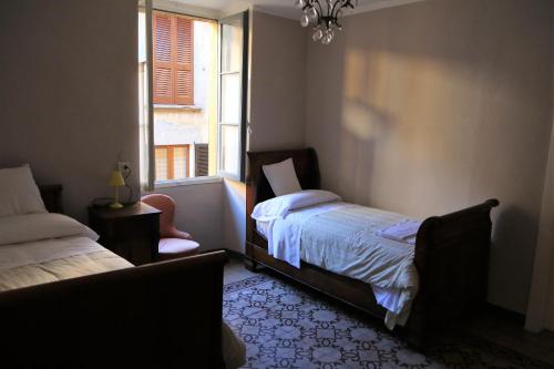 a bedroom with two beds and a window at Bed & Breakfast Dèco in Torno