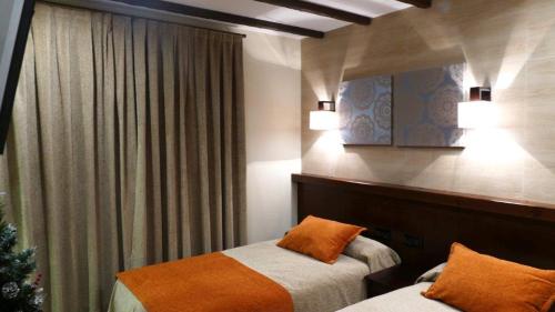 a bedroom with two beds and a christmas tree at Hotel Rural La Cabrera in Robledo del Buey