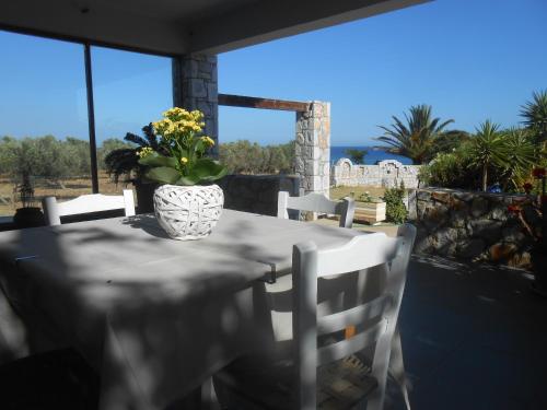 a table with a vase of flowers on a patio at Serenity Hideaway in Palaiochóra