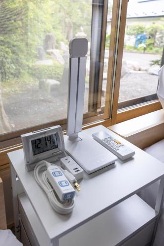 a clock and a thermometer on a table next to a window at 軽井沢フォーシーズホテル in Karuizawa