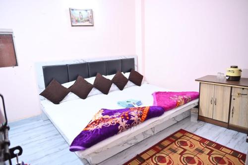 a bed with pillows on it in a room at Geeta Homestay in Ujjain