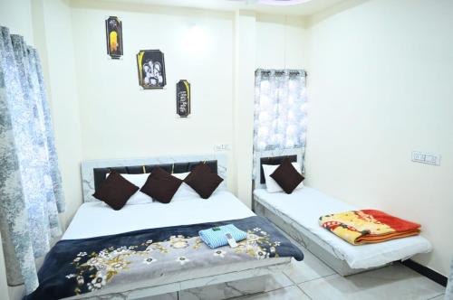 a bedroom with two beds with pillows at Geeta Homestay in Ujjain