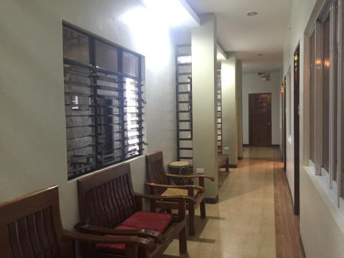 a hallway with chairs and a table and a window at Seaslugs Travellers Inn in El Nido