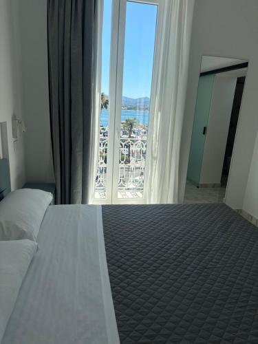 a bedroom with a bed with a view of the ocean at Liberty Palace in Milazzo