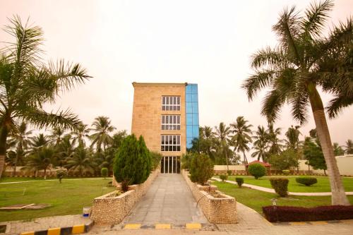 a building with palm trees in front of it at لاكجري صلالة Luxury salalah Villa in Salalah