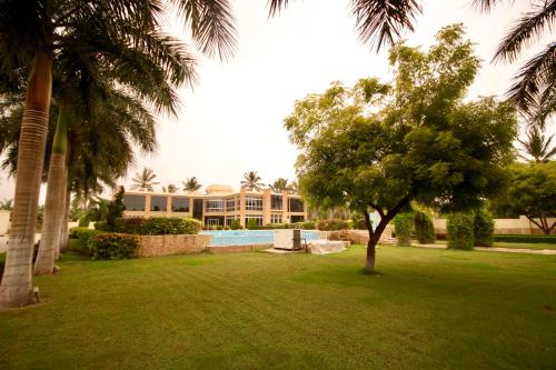 a yard with trees and a building with a swimming pool at لاكجري صلالة Luxury salalah Villa in Salalah