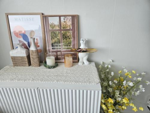 a window sill with a table with vases and flowers at 에벤에셀 in Busan