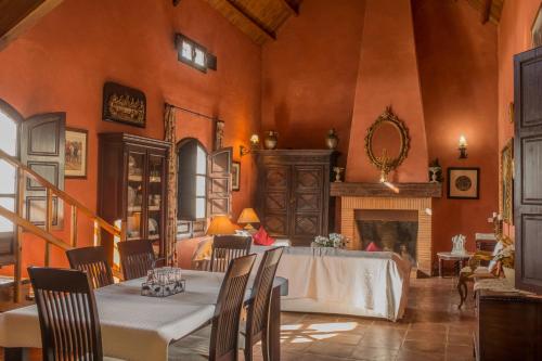 a dining room with a table and a fireplace at Reservaloen Hacienda las Marciagas in Benacazón